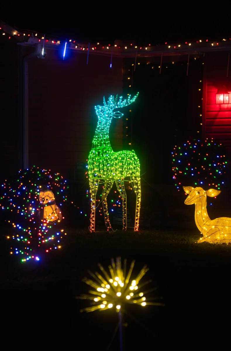 Illuminated reindeer decoration in a colorful Christmas display