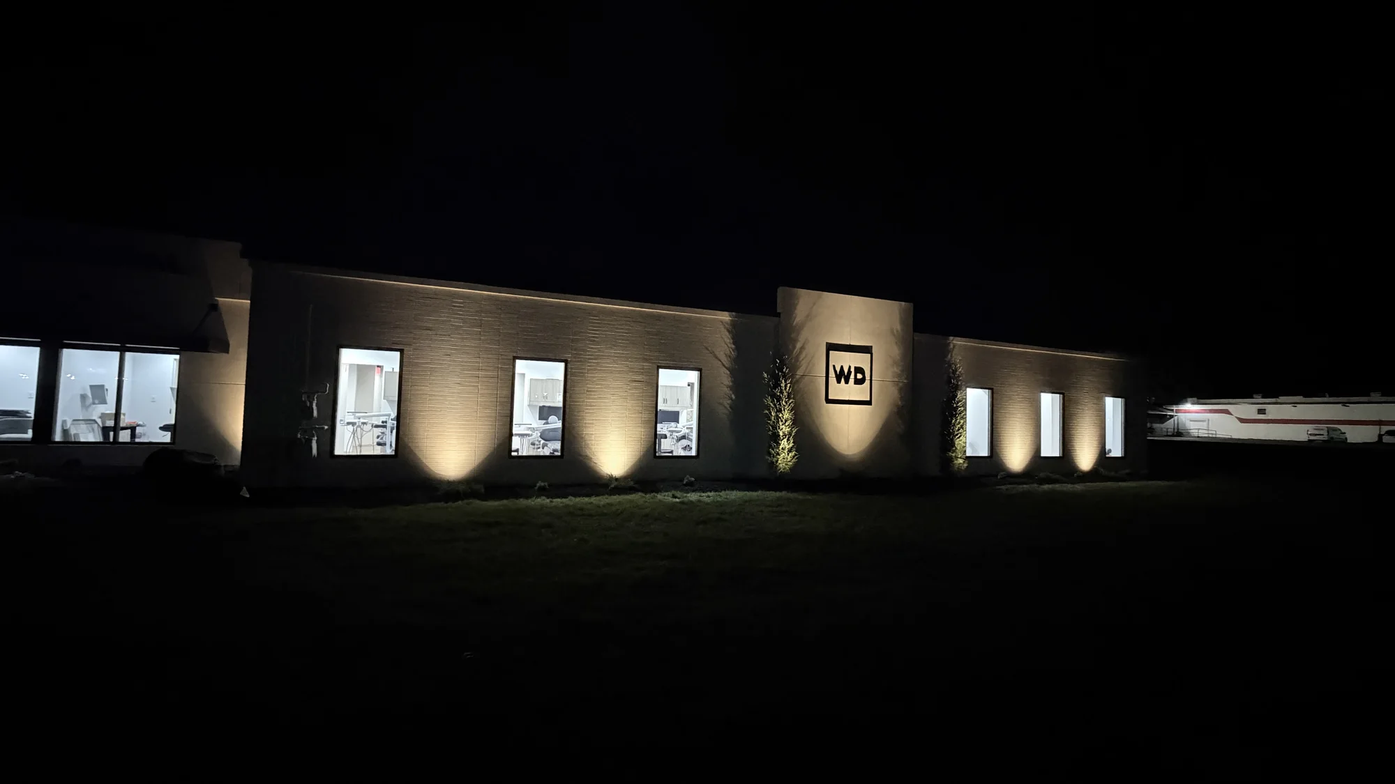 Warm architectural lighting across a brick commercial building at night